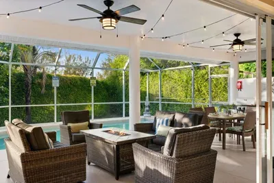 Outdoor Oasis: Relax by the pool in style with comfy seating and sparkling string lights!