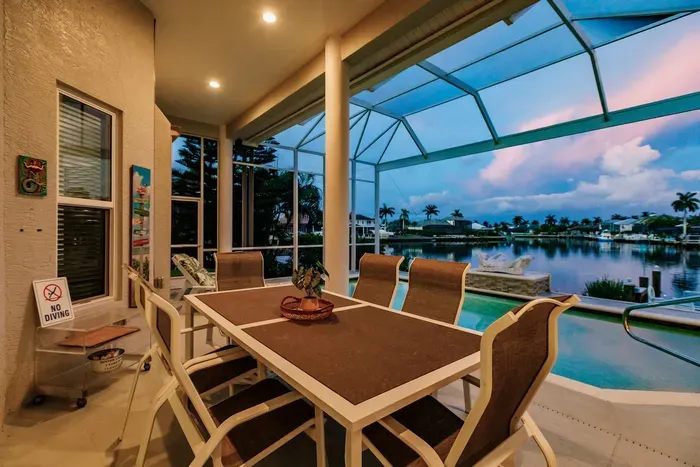 Screened Patio: Dine al fresco with a stunning waterfront view and vibrant Florida sunsets!