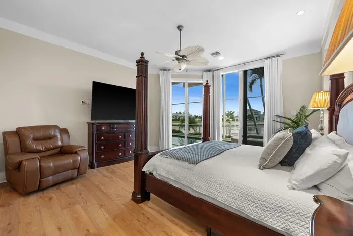Bright waterfront bedroom with four-poster bed and relaxing views
