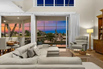 Spacious waterfront living room with panoramic sunset views