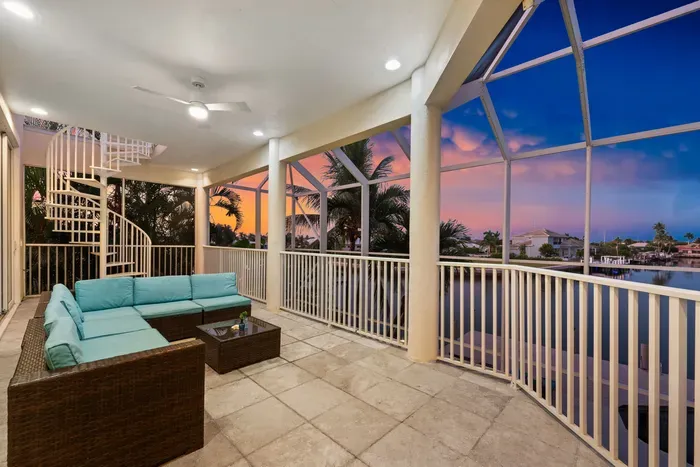Screened waterfront lanai with sunset views and stylish outdoor seating