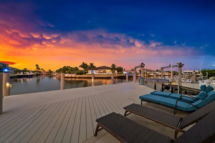 Private waterfront deck with lounge chairs and stunning sunset canal views