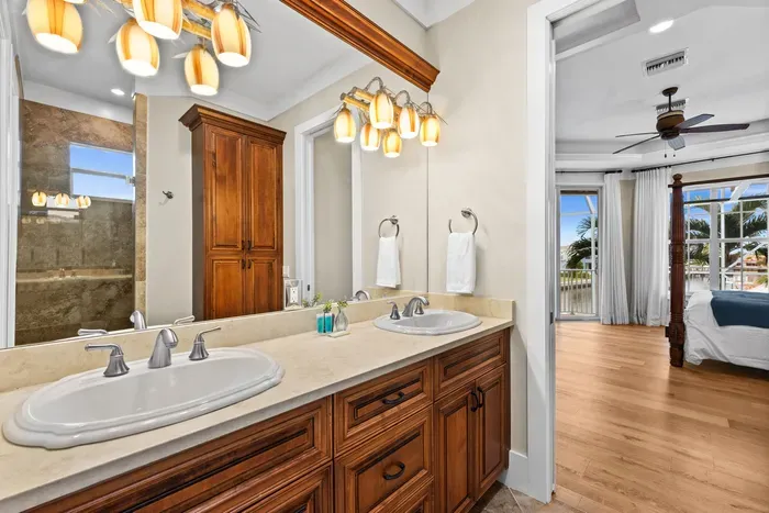 Spacious double-vanity bath with spa shower and bedroom views