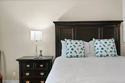 Coastal-inspired bedroom with crisp linens and elegant dark wood furnishings