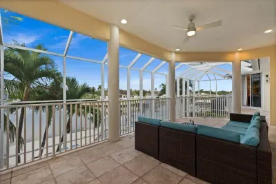 Screened waterfront lanai with comfy seating and tropical views