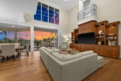 Stunning waterfront great room with soaring ceilings and sunset views