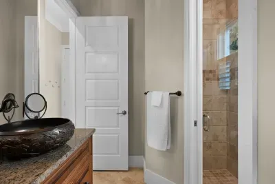 Elegant bathroom with granite vanity and glass-tiled walk-in shower