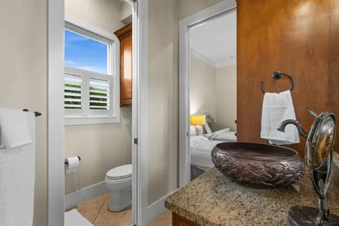 Elegant bath with granite vanity, vessel sink & bright private water closet