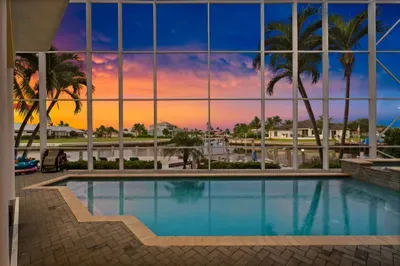 Screened waterfront pool with stunning tropical sunset views