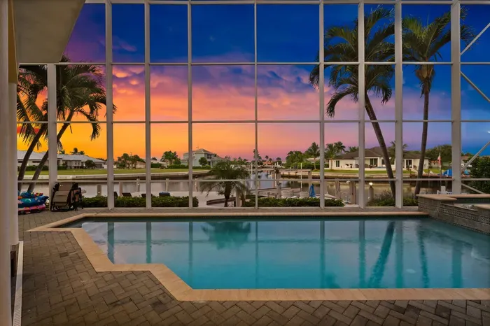 Screened waterfront pool with stunning tropical sunset views