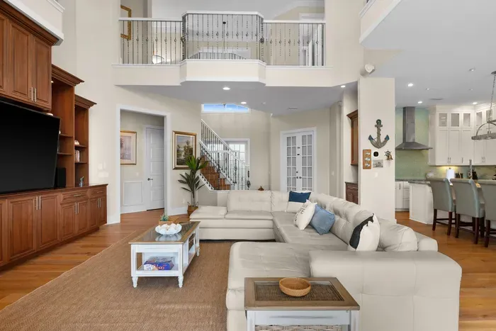 Spacious open living room with soaring ceilings and elegant balcony views