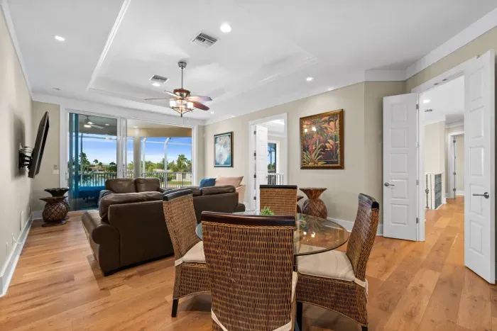 Bright living space with screened balcony and tropical views