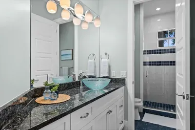 Bright modern bath with granite vanity and sleek walk-in shower