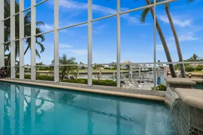 Screened waterfront pool with palm views and a relaxing tropical vibe