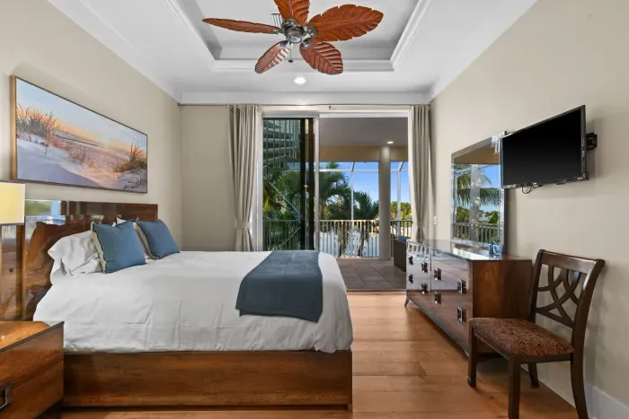 Spacious king bedroom with private balcony and tropical palm views