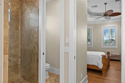 Ensuite bedroom with spa-style tiled shower and bright coastal touches