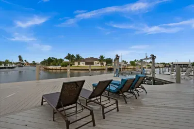 Spacious waterfront deck with lounge chairs, private dock, and canal views