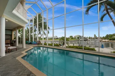 Screened waterfront pool with palm views and a relaxing covered lanai