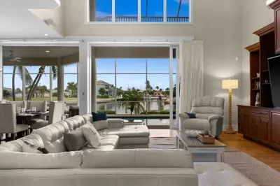 Bright waterfront living room with soaring ceilings and panoramic views