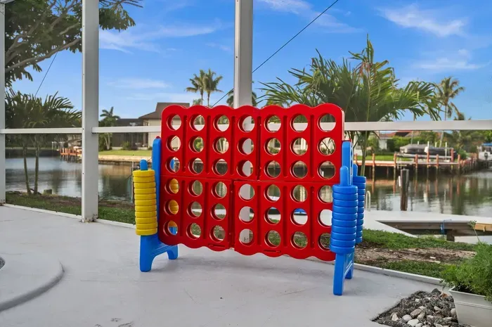 Screened waterfront patio with giant Connect Four and canal views