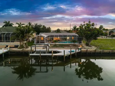Waterfront retreat with private dock, screened pool, and sunset views