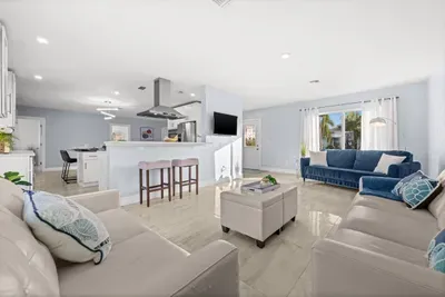 Bright open-concept living room with modern kitchen and abundant natural light