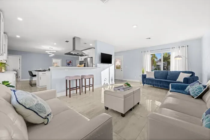 Bright open-concept living room with modern kitchen and abundant natural light