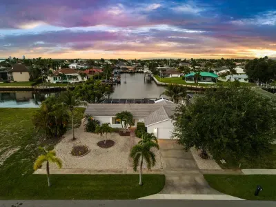 Waterfront canal home with tropical landscaping and stunning sunset views