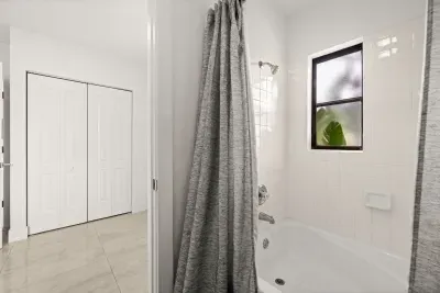 Bright full bathroom with tub-shower combo and natural light