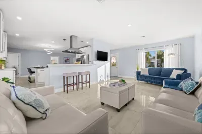 Bright open-concept living room with modern kitchen and abundant natural light