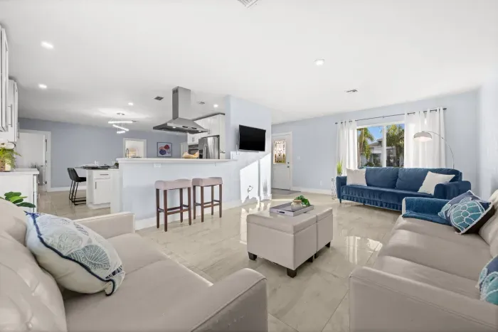 Bright open-concept living room with modern kitchen and abundant natural light