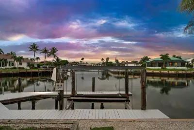 Private waterfront dock with serene canal views and stunning sunset skies