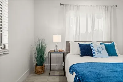 Bright coastal-style bedroom with soft natural light and blue accents