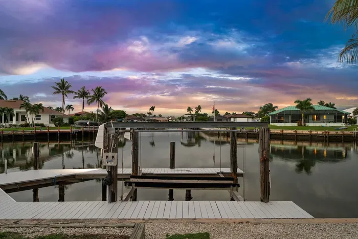 Private waterfront dock with serene canal views and stunning sunset skies
