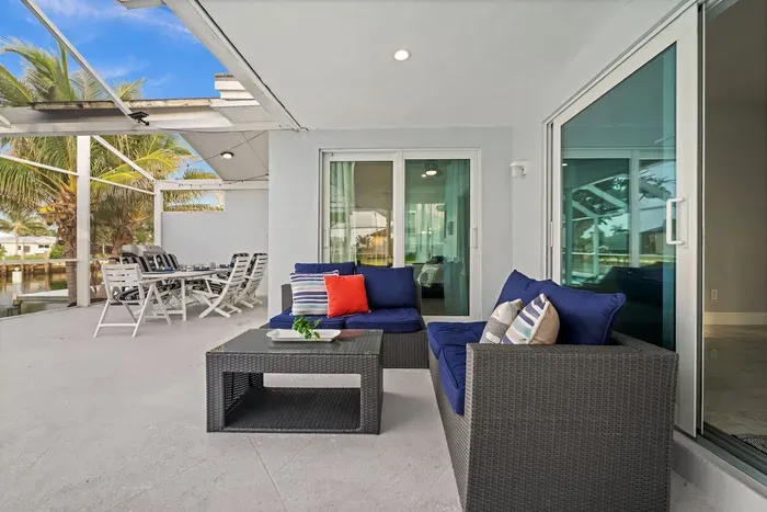 Covered waterfront patio with lounge seating and outdoor dining