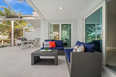 Covered waterfront patio with lounge seating and outdoor dining