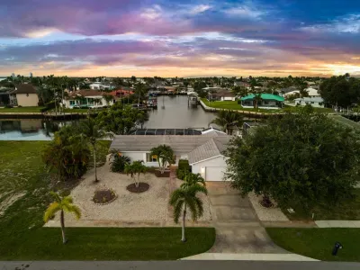 Waterfront canal home with tropical landscaping and stunning sunset views