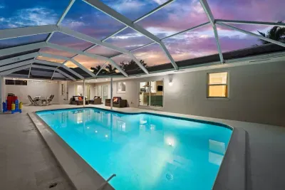 Spacious screened lanai with a glowing private pool at sunset