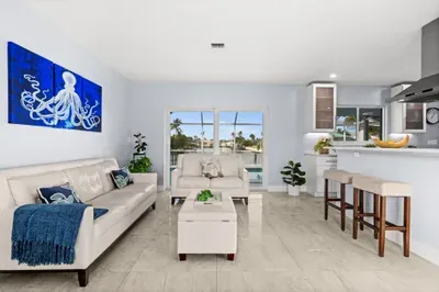 Bright waterfront living room with modern decor and open kitchen bar