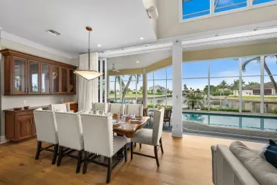 Elegant dining space with poolside waterfront views and abundant natural light