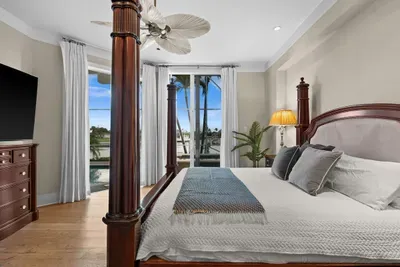 Elegant waterfront bedroom with four-poster bed and serene water views