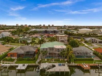 Canal-front retreat with private dock, screened pool, and palm-lined views