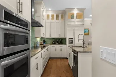Bright gourmet kitchen with island, granite counters, and stainless appliances
