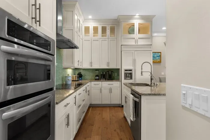 Bright gourmet kitchen with island, granite counters, and stainless appliances