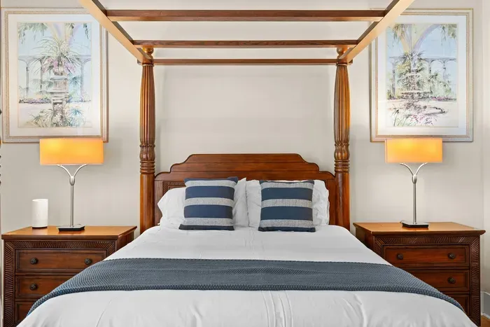 Elegant four-poster bedroom with warm lighting and tropical-inspired decor