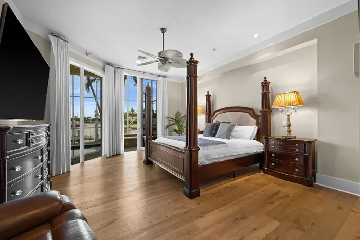 Elegant primary suite with four-poster bed and private balcony views