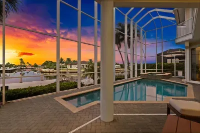 Screened waterfront pool and spa with breathtaking sunset views