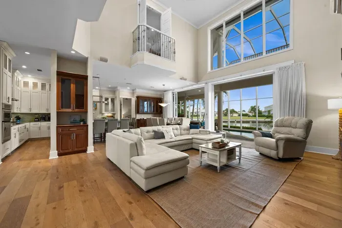 Bright waterfront great room with soaring ceilings and panoramic views