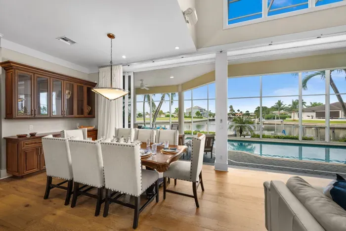 Elegant dining space with poolside waterfront views and abundant natural light