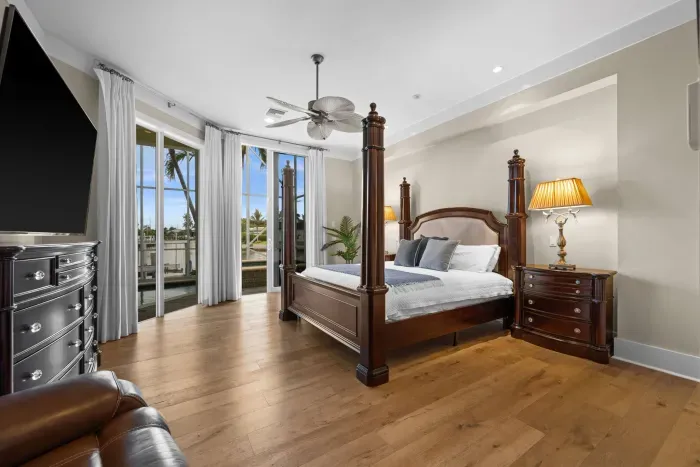 Elegant primary suite with four-poster bed and private balcony views